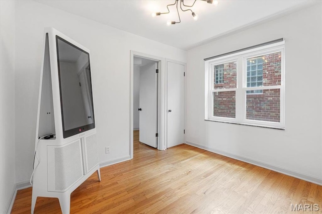 5660 Oleatha Ave, Saint Louis, MO 63139 - unfurnished bedroom with light wood-style flooring and a chandelier