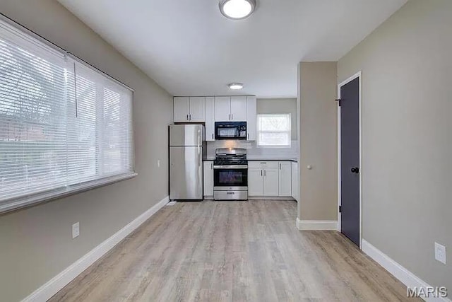 675 Pimlico Dr, Florissant, MO 63033 - kitchen with stainless steel appliances, white cabinetry, and light wood finished floors