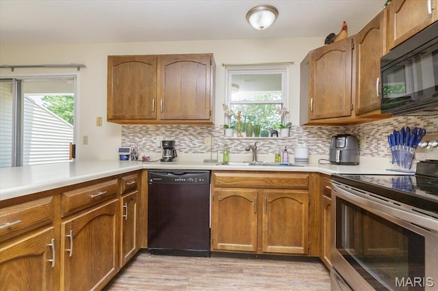 23 Trailside Ct Unit 2, Saint Peters, MO 63303 - kitchen with black appliances, light countertops, decorative backsplash, light wood finished floors, and brown cabinets
