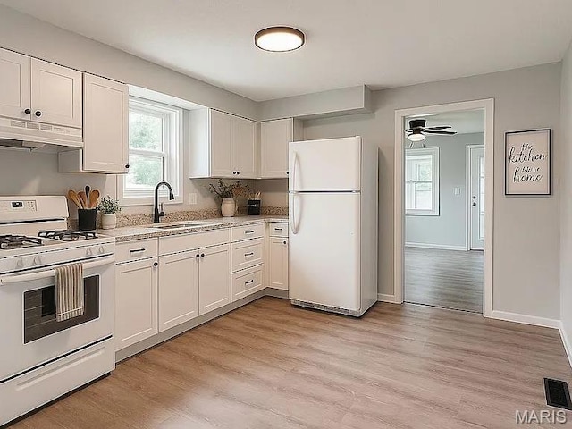 1412 N Olive St, Mexico, MO 65265 - kitchen with white appliances, under cabinet range hood, white cabinets, light wood-type flooring, and a ceiling fan