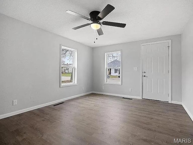 1412 N Olive St, Mexico, MO 65265 - empty room featuring plenty of natural light, wood finished floors, a ceiling fan, and a textured ceiling