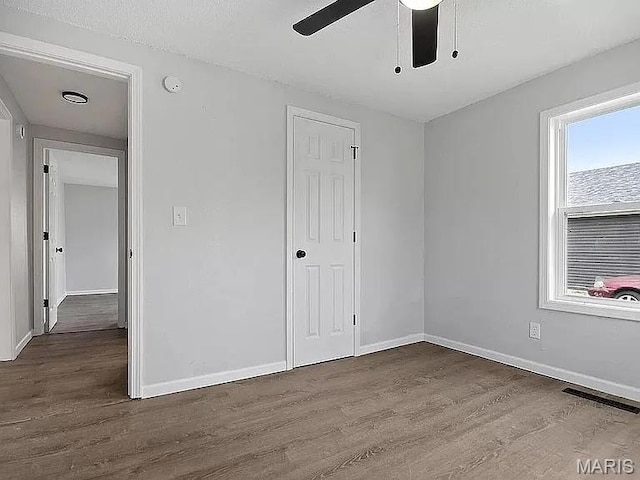 1412 N Olive St, Mexico, MO 65265 - unfurnished bedroom featuring wood finished floors, a ceiling fan, and a closet