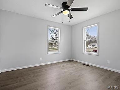 1412 N Olive St, Mexico, MO 65265 - empty room with plenty of natural light, ceiling fan, and wood finished floors
