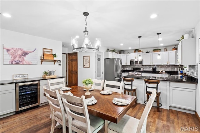 13345 Iberg Rd, Highland, IL 62249 - dining room with wine cooler, a chandelier, recessed lighting, and wood finished floors