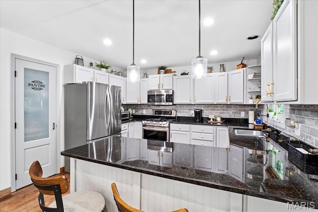13345 Iberg Rd, Highland, IL 62249 - kitchen with appliances with stainless steel finishes, open shelves, a peninsula, decorative backsplash, and recessed lighting