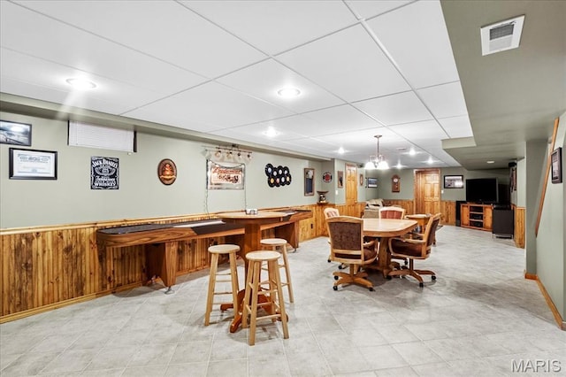 13345 Iberg Rd, Highland, IL 62249 - dining area with wooden walls, a wainscoted wall, bar, and a paneled ceiling