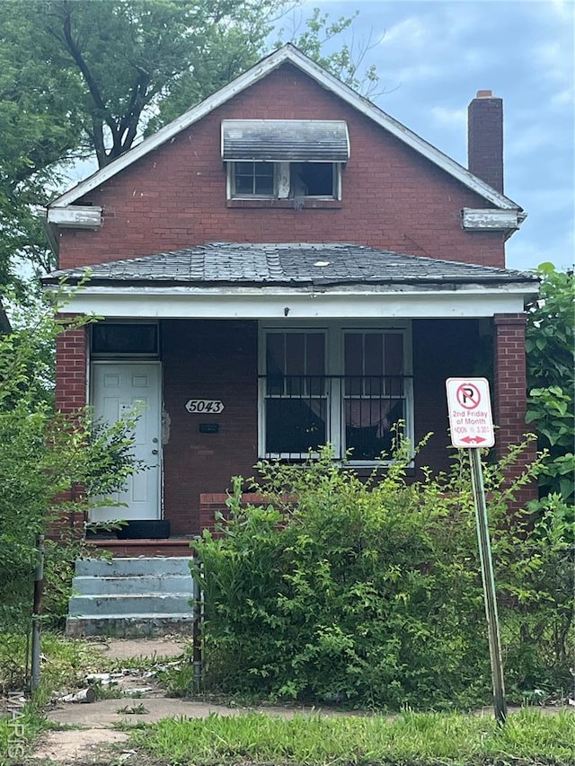 5043 Emerson Ave, Saint Louis, MO 63120 - view of front of property with a chimney, brick siding, and a porch