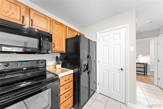 856 Hemingway Ln Unit D, Weldon Spring, MO 63304 - kitchen featuring black appliances, light tile patterned flooring, light countertops, and brown cabinetry
