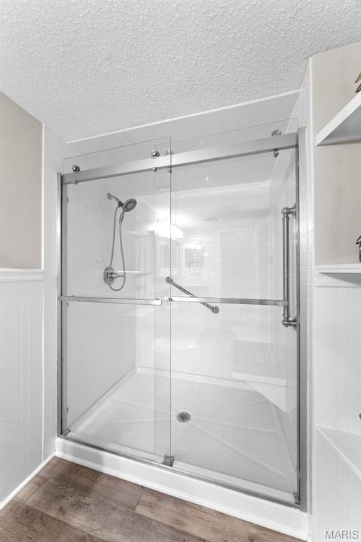 856 Hemingway Ln Unit D, Weldon Spring, MO 63304 - full bath featuring a stall shower, wood finished floors, a textured ceiling, and a wainscoted wall