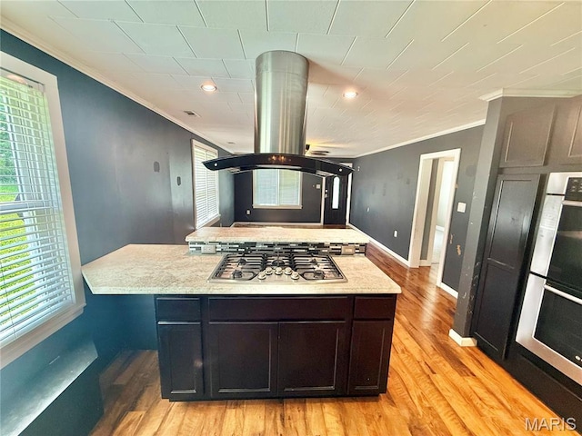 904 Vernon St, Farmington, MO 63640 - kitchen featuring stainless steel gas cooktop, ornamental molding, multiple ovens, light wood-type flooring, and island exhaust hood