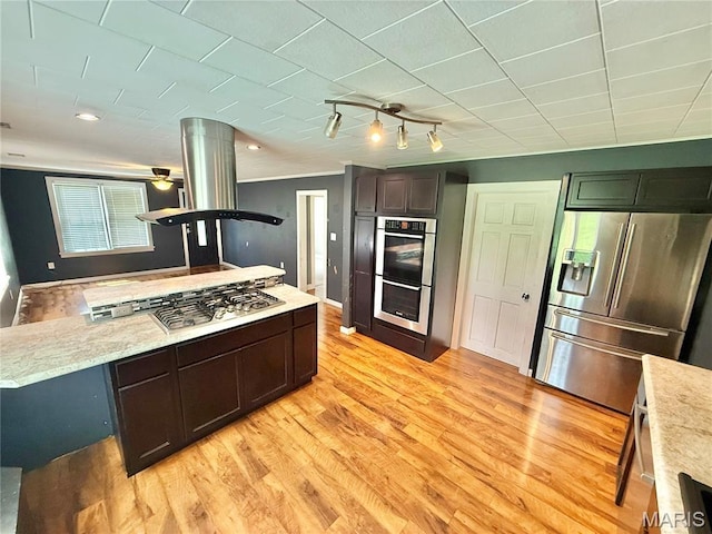904 Vernon St, Farmington, MO 63640 - kitchen with appliances with stainless steel finishes, light wood-style floors, dark brown cabinetry, and decorative columns
