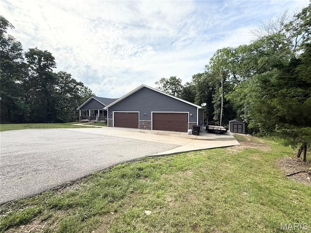 22115 Royce Ln, Waynesville, MO 65583 - view of front of property featuring a shed, driveway, a front yard, and an attached garage