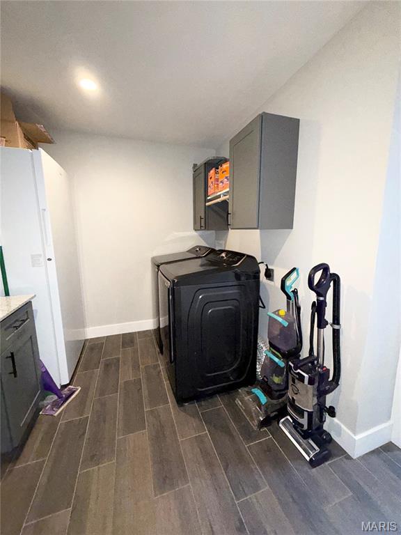 22115 Royce Ln, Waynesville, MO 65583 - laundry area with cabinet space, wood tiled floors, washer and clothes dryer, and a wood stove
