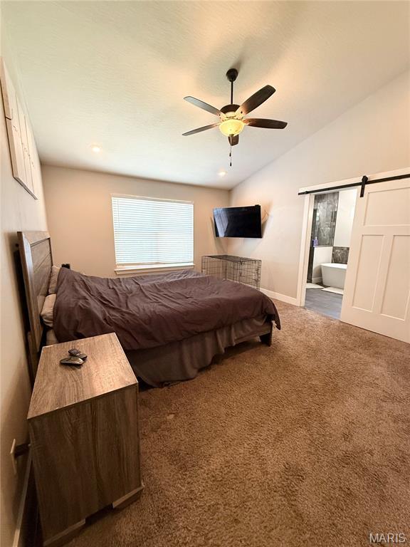 22115 Royce Ln, Waynesville, MO 65583 - bedroom with a barn door, carpet flooring, a ceiling fan, lofted ceiling, and ensuite bath