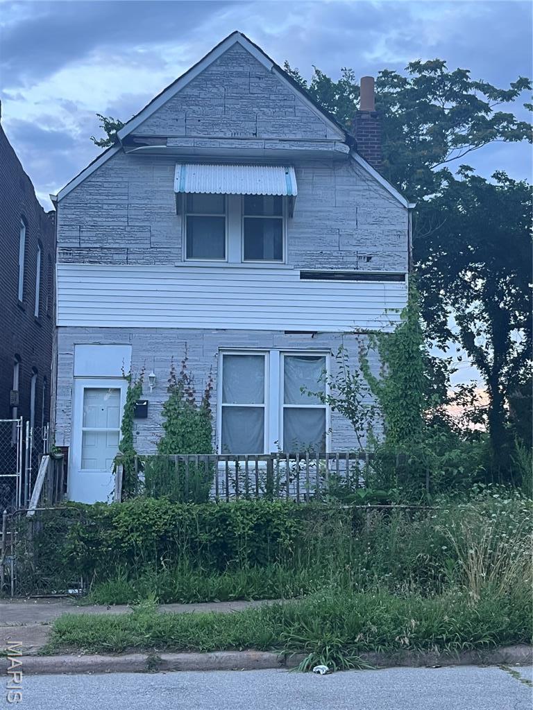 3849 Cottage Ave, Saint Louis, MO 63113 - view of property exterior with a chimney and stone siding