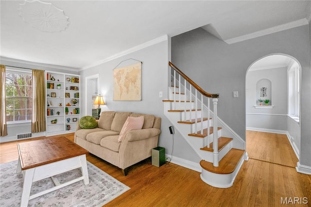 1000 Diversey Dr, Crestwood, MO 63126 - living room with wood finished floors, ornamental molding, arched walkways, stairway, and built in shelves