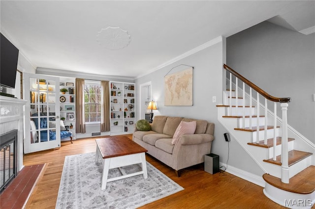 1000 Diversey Dr, Crestwood, MO 63126 - living area with a fireplace with flush hearth, ornamental molding, wood finished floors, stairs, and built in shelves
