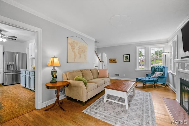 1000 Diversey Dr, Crestwood, MO 63126 - living area with stairway, a fireplace with flush hearth, ornamental molding, light wood-type flooring, and a ceiling fan