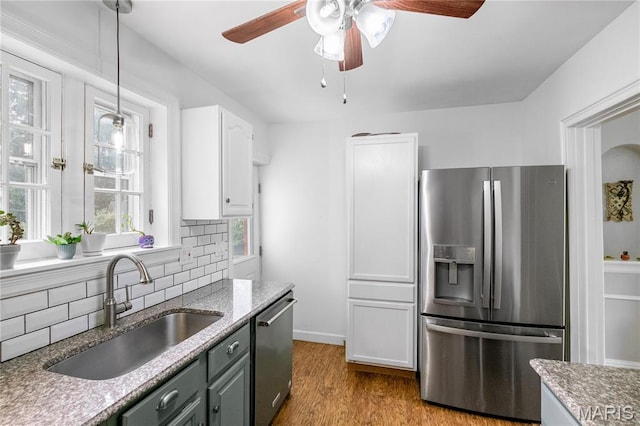 1000 Diversey Dr, Crestwood, MO 63126 - kitchen with appliances with stainless steel finishes, tasteful backsplash, a ceiling fan, white cabinetry, and wood finished floors