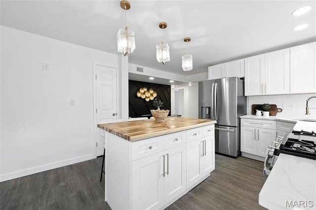 9441 Ridge Ave, Overland, MO 63114 - kitchen featuring stainless steel appliances, dark wood-style flooring, a center island, decorative backsplash, and white cabinets