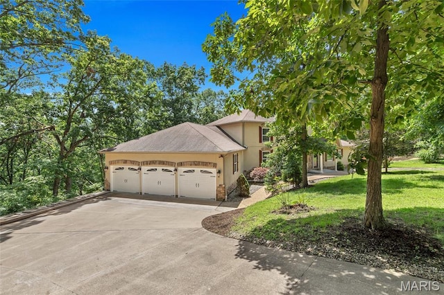 3516 Hawthorne Ridge Dr, Eureka, MO 63025 - view of side of home with an attached garage, stucco siding, concrete driveway, and a yard