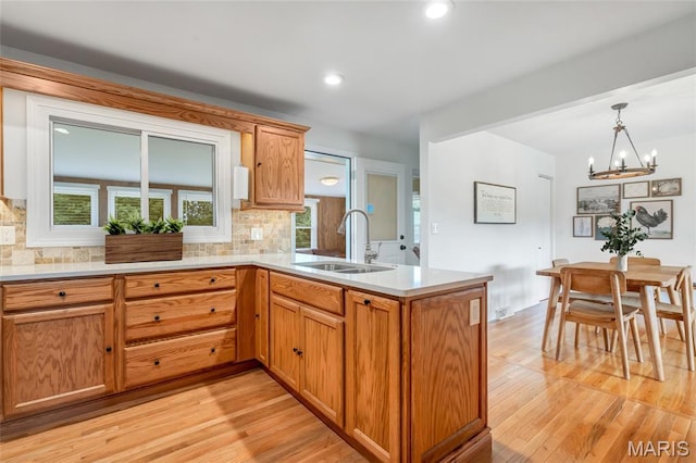 5701 State Road P, De Soto, MO 63020 - kitchen with a peninsula, a chandelier, backsplash, light wood-type flooring, and recessed lighting