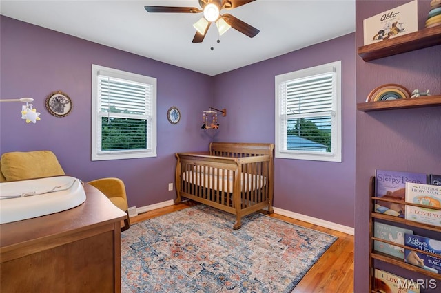 5701 State Road P, De Soto, MO 63020 - bedroom featuring a nursery area, wood finished floors, and a ceiling fan