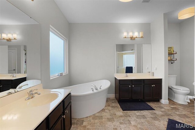 234 Lonepine Dr, Wentzville, MO 63385 - bathroom featuring stone finish floors, a shower stall, two vanities, and a freestanding bath