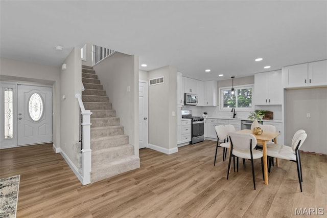 145 Aspencade Cir, Saint Peters, MO 63376 - dining area with light wood-type flooring, stairway, and recessed lighting