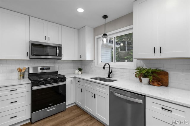 145 Aspencade Cir, Saint Peters, MO 63376 - kitchen featuring stainless steel appliances, white cabinetry, light stone countertops, pendant lighting, and decorative backsplash