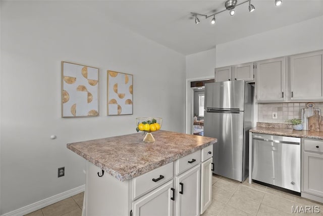 5524 Devonshire Ave, Saint Louis, MO 63109 - kitchen featuring appliances with stainless steel finishes, light tile patterned floors, backsplash, light countertops, and a kitchen island
