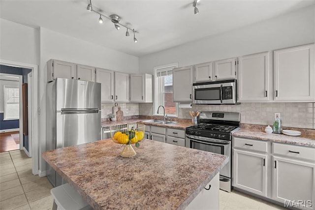 5524 Devonshire Ave, Saint Louis, MO 63109 - kitchen featuring stainless steel appliances, tasteful backsplash, a center island, and light tile patterned floors
