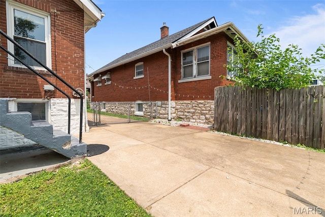 5524 Devonshire Ave, Saint Louis, MO 63109 - view of property exterior with a chimney, brick siding, and a patio