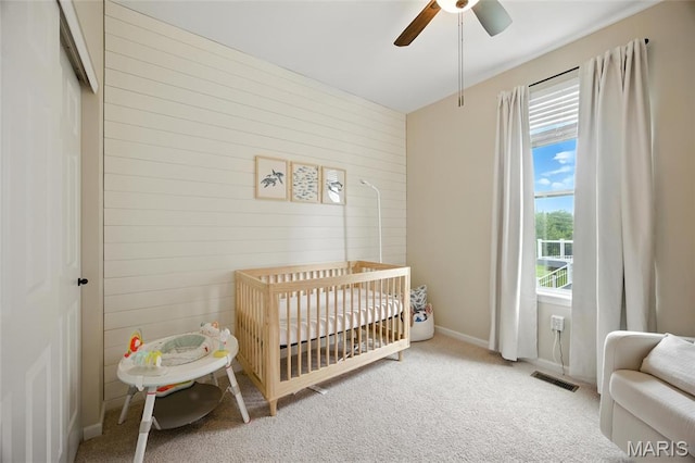 213 Dell View Dr, Arnold, MO 63010 - carpeted bedroom with multiple windows, a nursery area, ceiling fan, and wooden walls