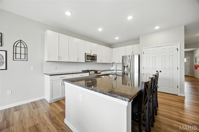 213 Dell View Dr, Arnold, MO 63010 - kitchen featuring appliances with stainless steel finishes, a kitchen breakfast bar, light wood-type flooring, an island with sink, and recessed lighting