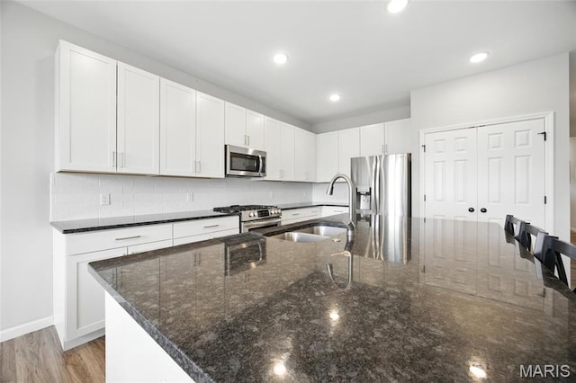 213 Dell View Dr, Arnold, MO 63010 - kitchen featuring stainless steel appliances, decorative backsplash, dark stone countertops, and recessed lighting
