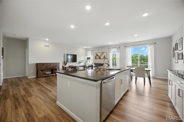 213 Dell View Dr, Arnold, MO 63010 - kitchen featuring dishwasher, wood finished floors, white cabinets, an island with sink, and recessed lighting