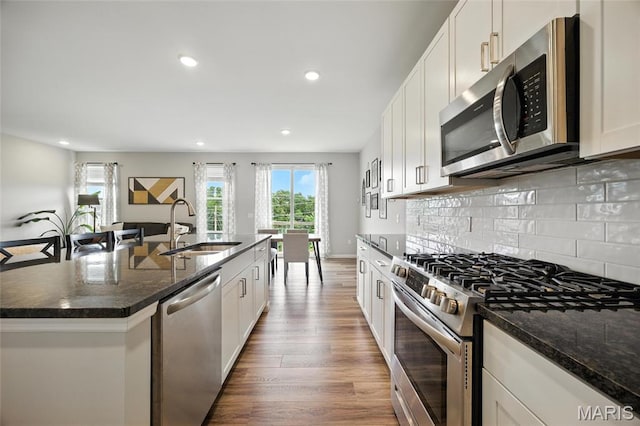 213 Dell View Dr, Arnold, MO 63010 - kitchen featuring appliances with stainless steel finishes, wood finished floors, recessed lighting, an island with sink, and white cabinetry
