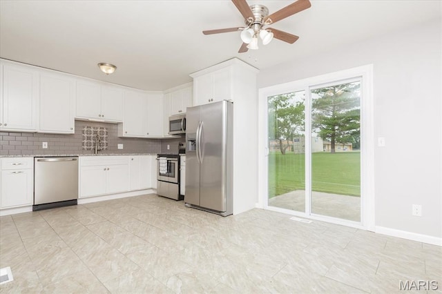 1655 Oakwood Dr, Ofallon, MO 63366 - kitchen with stainless steel appliances, white cabinetry, ceiling fan, tasteful backsplash, and light stone countertops
