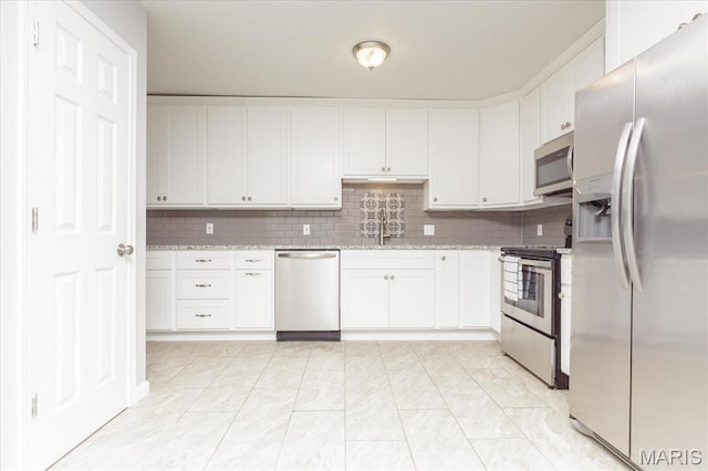 1655 Oakwood Dr, Ofallon, MO 63366 - kitchen featuring stainless steel appliances, white cabinetry, backsplash, and light stone counters