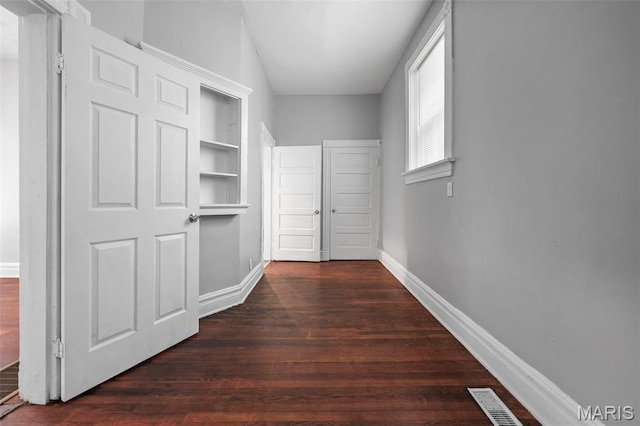 3921 Pennsylvania Ave, Saint Louis, MO 63118 - hall with dark wood-style floors and built in shelves
