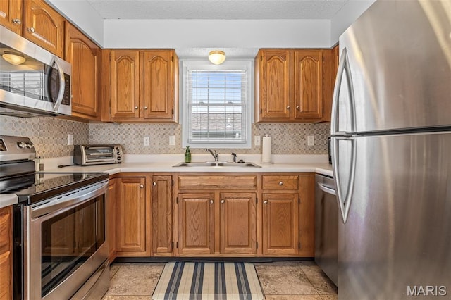 1531 Charmaine Dr, Bonne Terre, MO 63628 - kitchen featuring stainless steel appliances, light countertops, brown cabinets, and backsplash