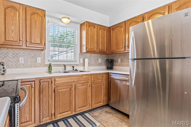 1531 Charmaine Dr, Bonne Terre, MO 63628 - kitchen with appliances with stainless steel finishes, light countertops, backsplash, brown cabinets, and a textured ceiling