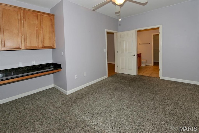 2636 S Mcknight Rd, Rock Hill, MO 63124 - kitchen featuring carpet floors, a ceiling fan, dark countertops, brown cabinets, and built in study area