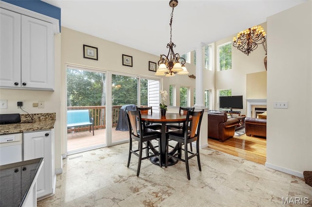 5 Hickory Glen Ct, Lake St Louis, MO 63367 - dining space with a chandelier, a fireplace, light marble finish flooring, and a high ceiling