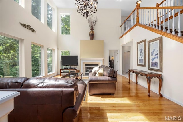 5 Hickory Glen Ct, Lake St Louis, MO 63367 - living room with a towering ceiling, light wood finished floors, a glass covered fireplace, and a chandelier