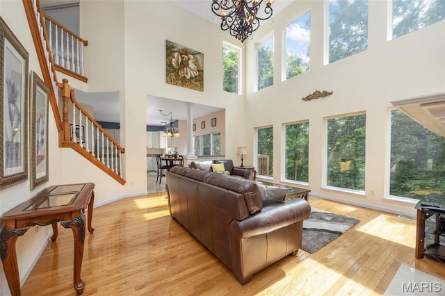 5 Hickory Glen Ct, Lake St Louis, MO 63367 - living area featuring a chandelier, light wood-style floors, a high ceiling, and healthy amount of natural light