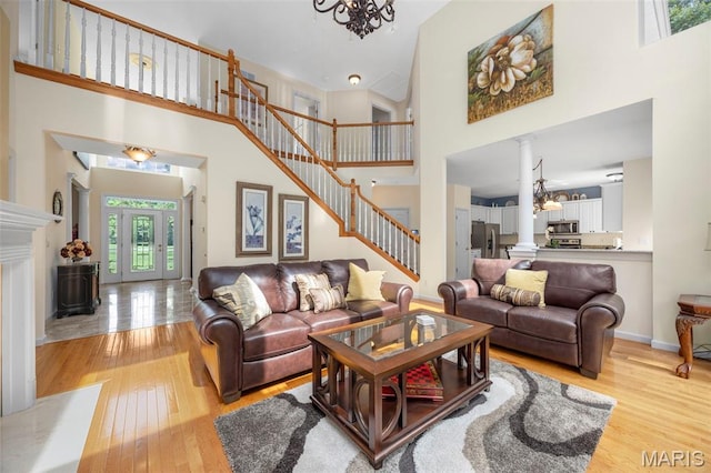 5 Hickory Glen Ct, Lake St Louis, MO 63367 - living area featuring a towering ceiling, a chandelier, stairs, light wood-style floors, and decorative columns