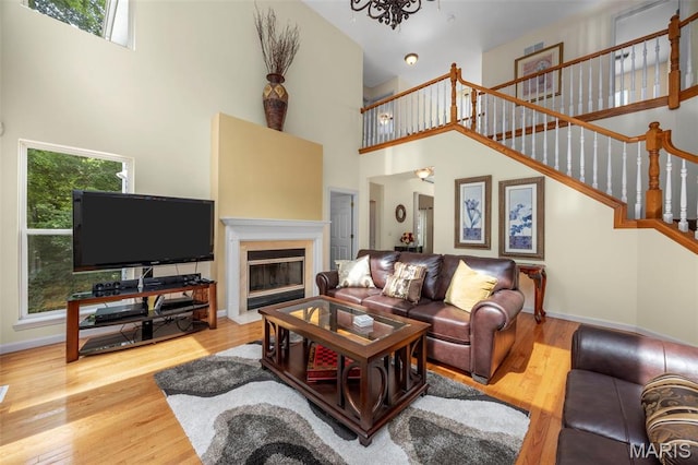 5 Hickory Glen Ct, Lake St Louis, MO 63367 - living room with a high ceiling, wood finished floors, stairway, a fireplace with flush hearth, and a chandelier