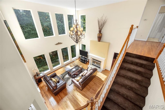 5 Hickory Glen Ct, Lake St Louis, MO 63367 - living room with wood finished floors, stairs, a chandelier, a towering ceiling, and a fireplace with flush hearth